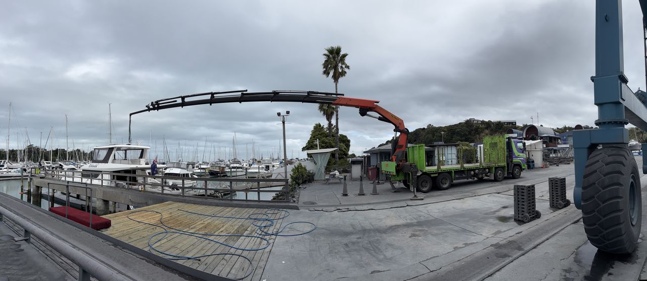 The crane boom extended across a marina car park