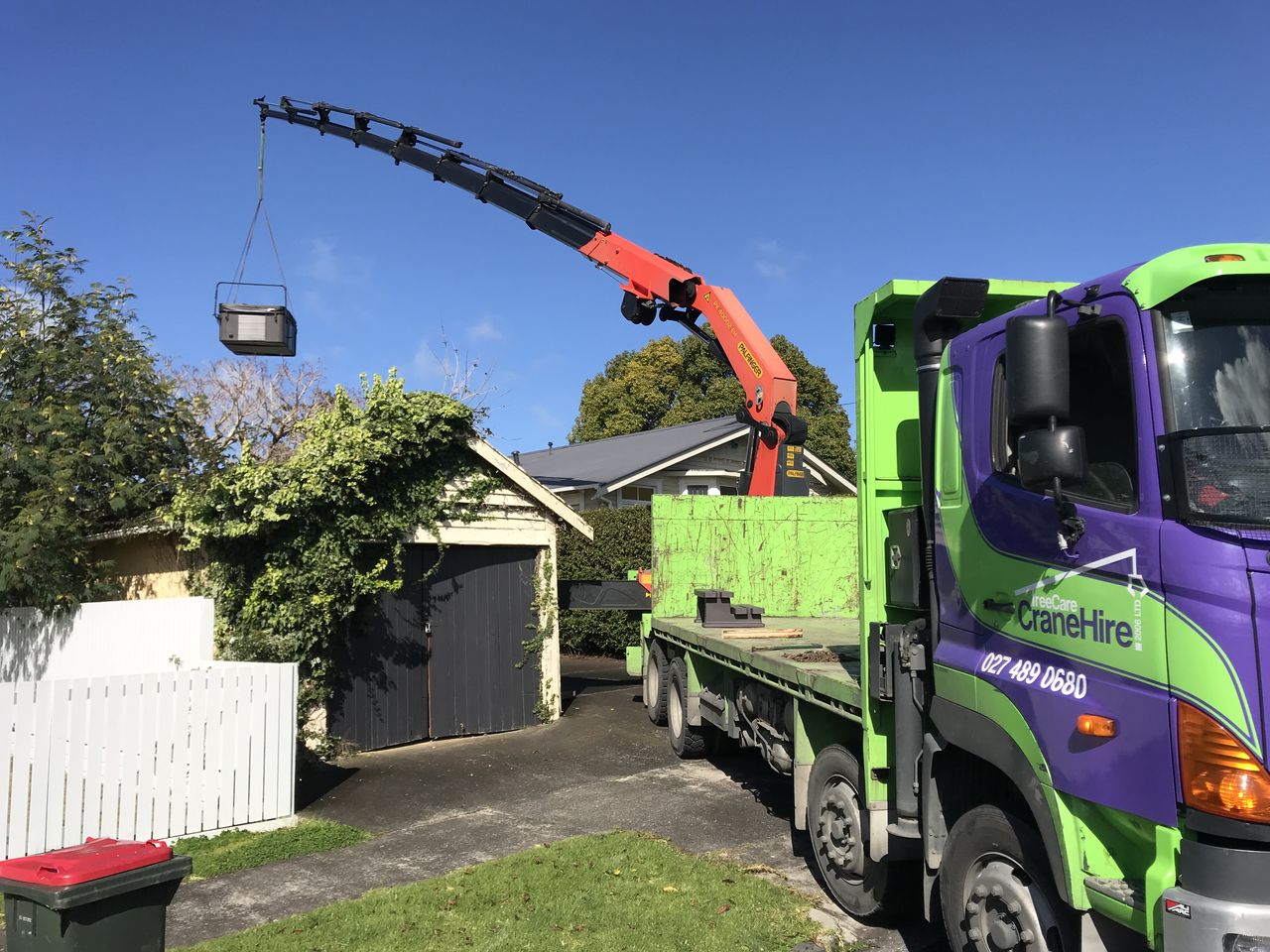 A load taken by crane over a house into the rear section