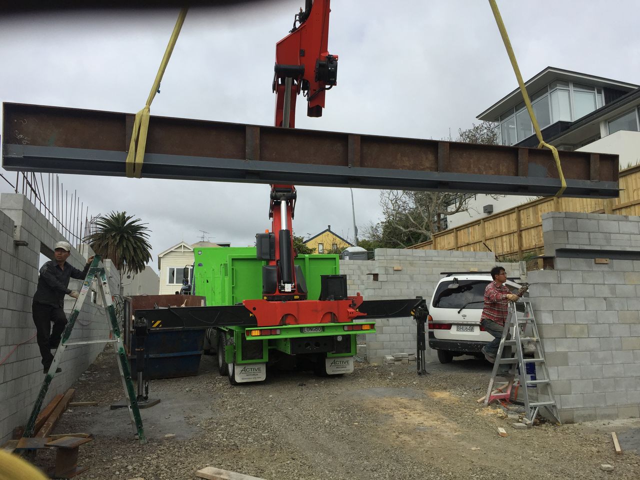 A steel beam being positioned by crane at a building site